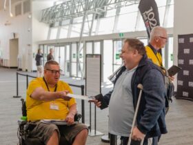 Volunteer greeting attendee at the Gold Coast Disability Expo 2023
