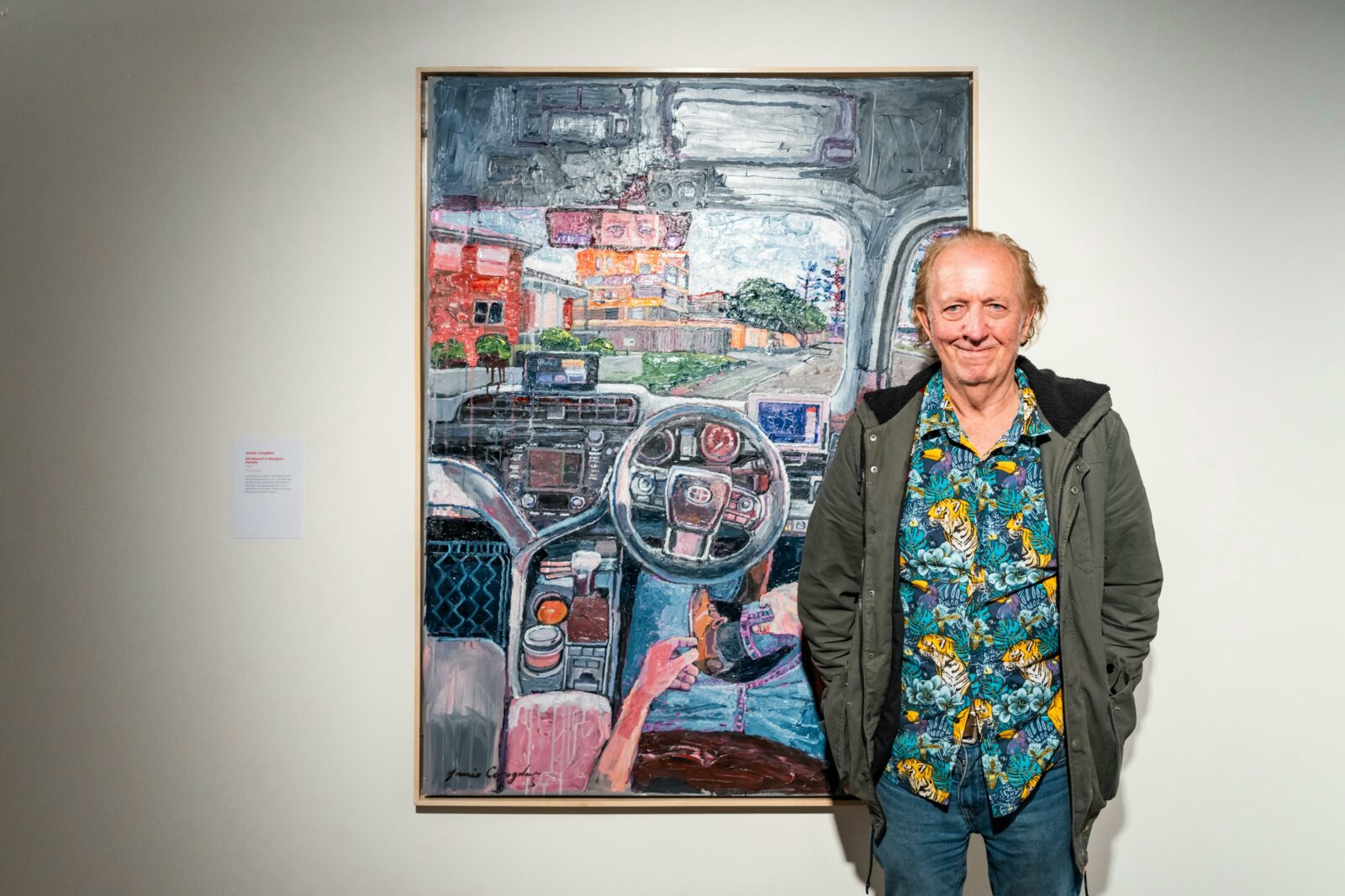 A middle-aged man standing in front of a large painting.