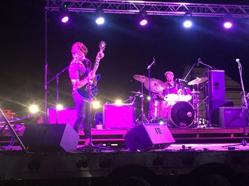 Band on stage at festival in purple light