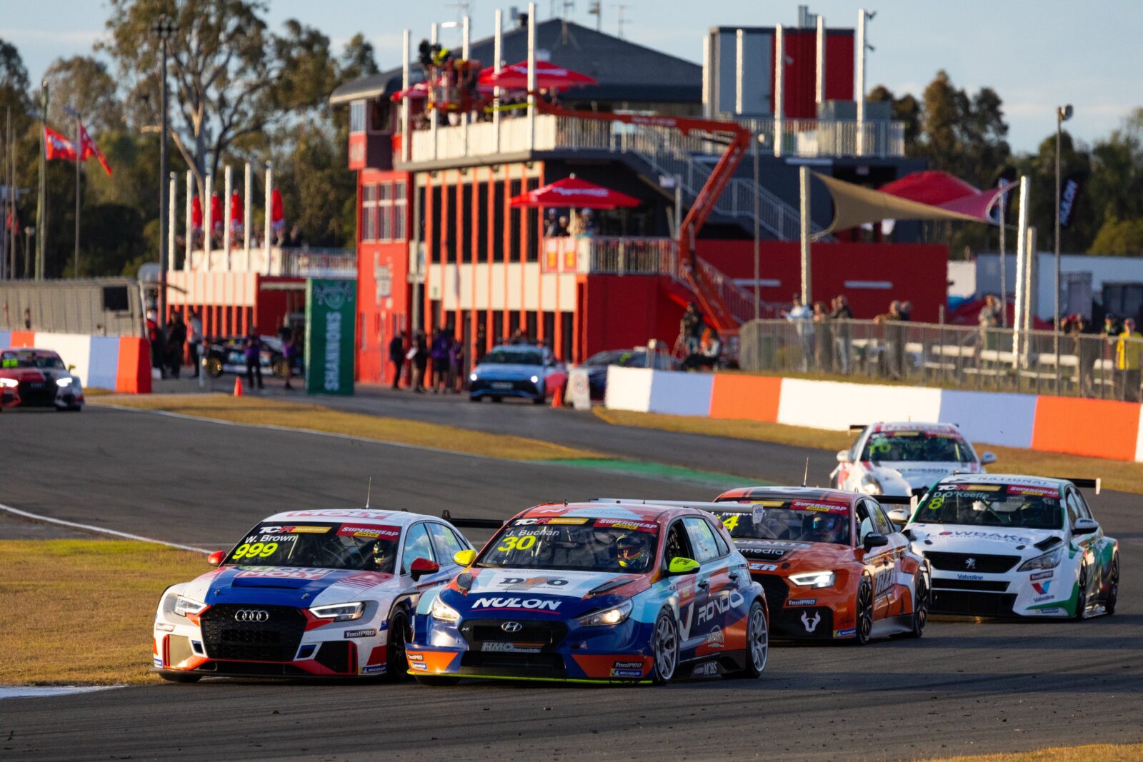 TCR Australia cars grouped together making a turn around a track