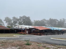 photo showing Burrum Heads Hotel Motel facade with outdoor seating area on a foggy morning