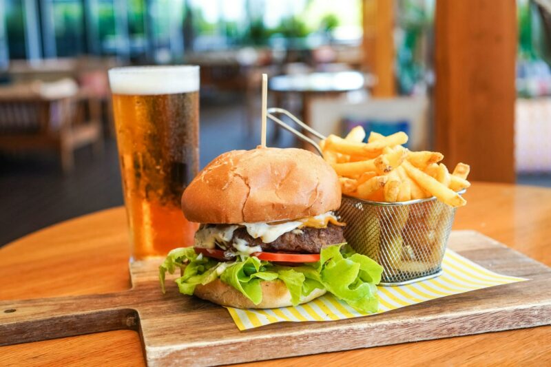 An image featuring a burger, chips & beverage