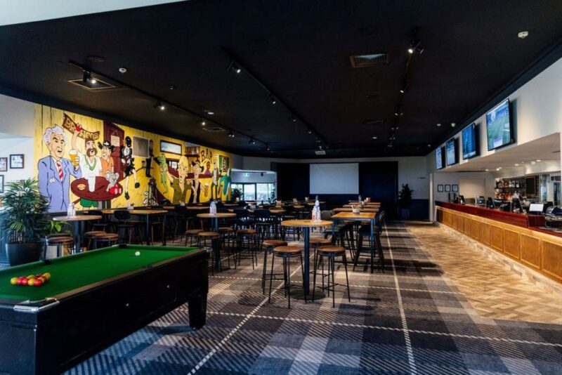 Photo shows the freshly renovated sports bar with pool table, projector screen and live music stage
