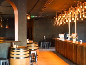 Copper lights above a copper and timber long bar. Wine barrels and seats in front of archways