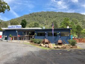 Photo of the Somerset Dam General Store - blue building with mountain and blue sky in the bacground