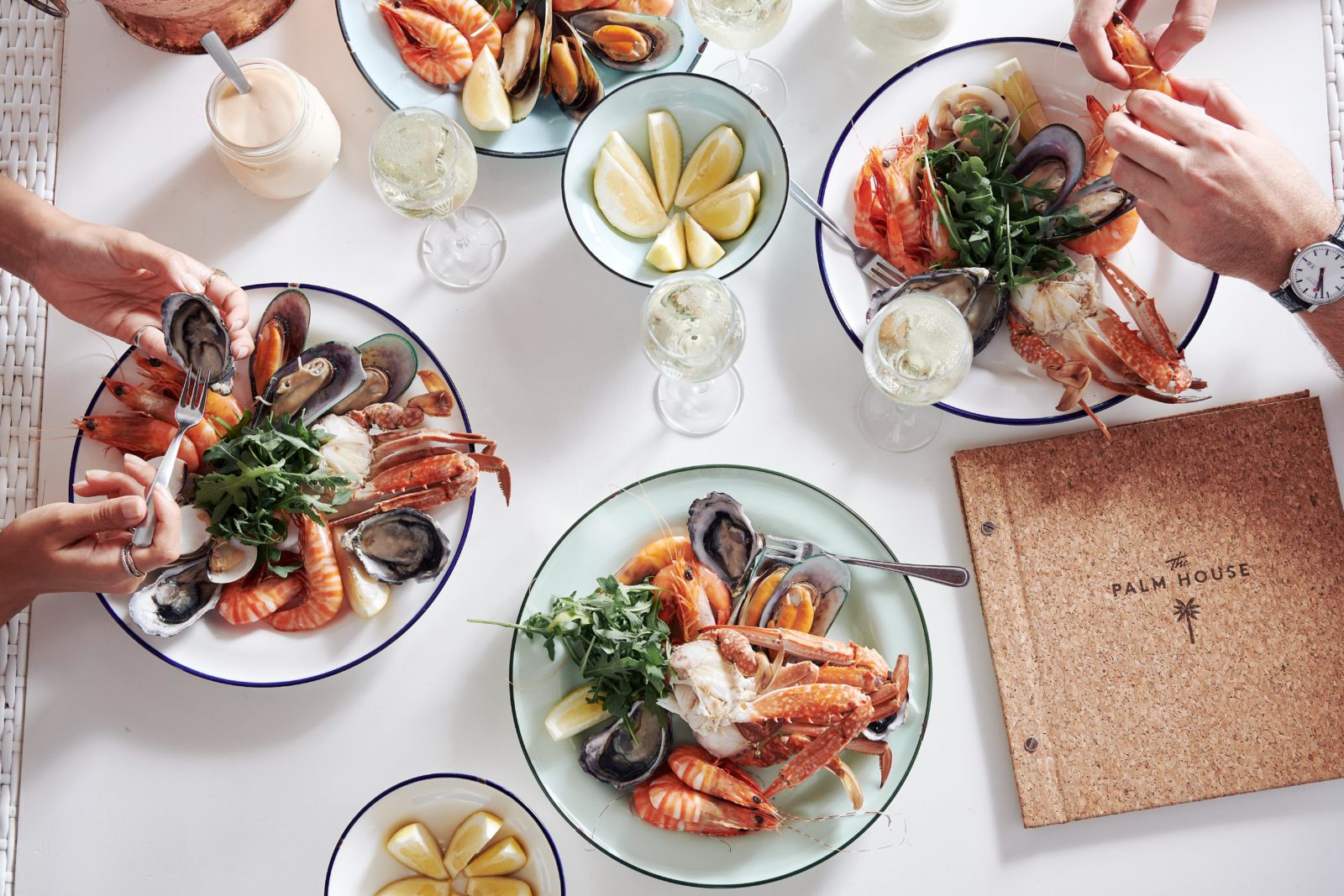 Various plates of seafood dishes on a white table