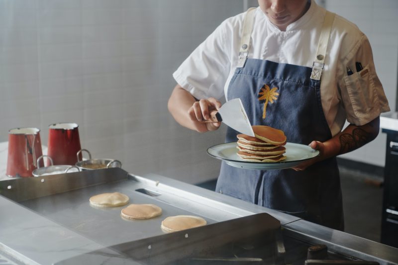 Chef cooking pancakes and serving them on a plate