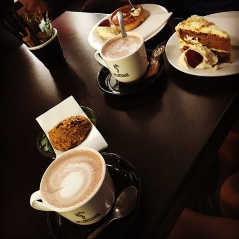 photo showing cups of coffee and pieces of cake arranged nicely on a table at Toast Espresso Bar