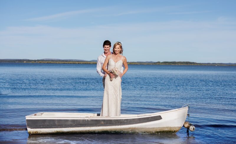 bride and groom pose in beach Redland Bay Golf Club