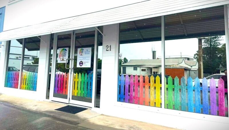 picture of front of building with rainbow fence and signage saying My Spectrum Services