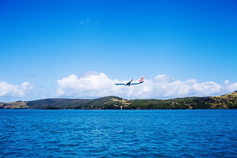 Aircraft landing in the distance at the island airport located right next to the ocean