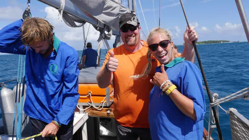 Crew and guest after hoisting sail on Ocean free