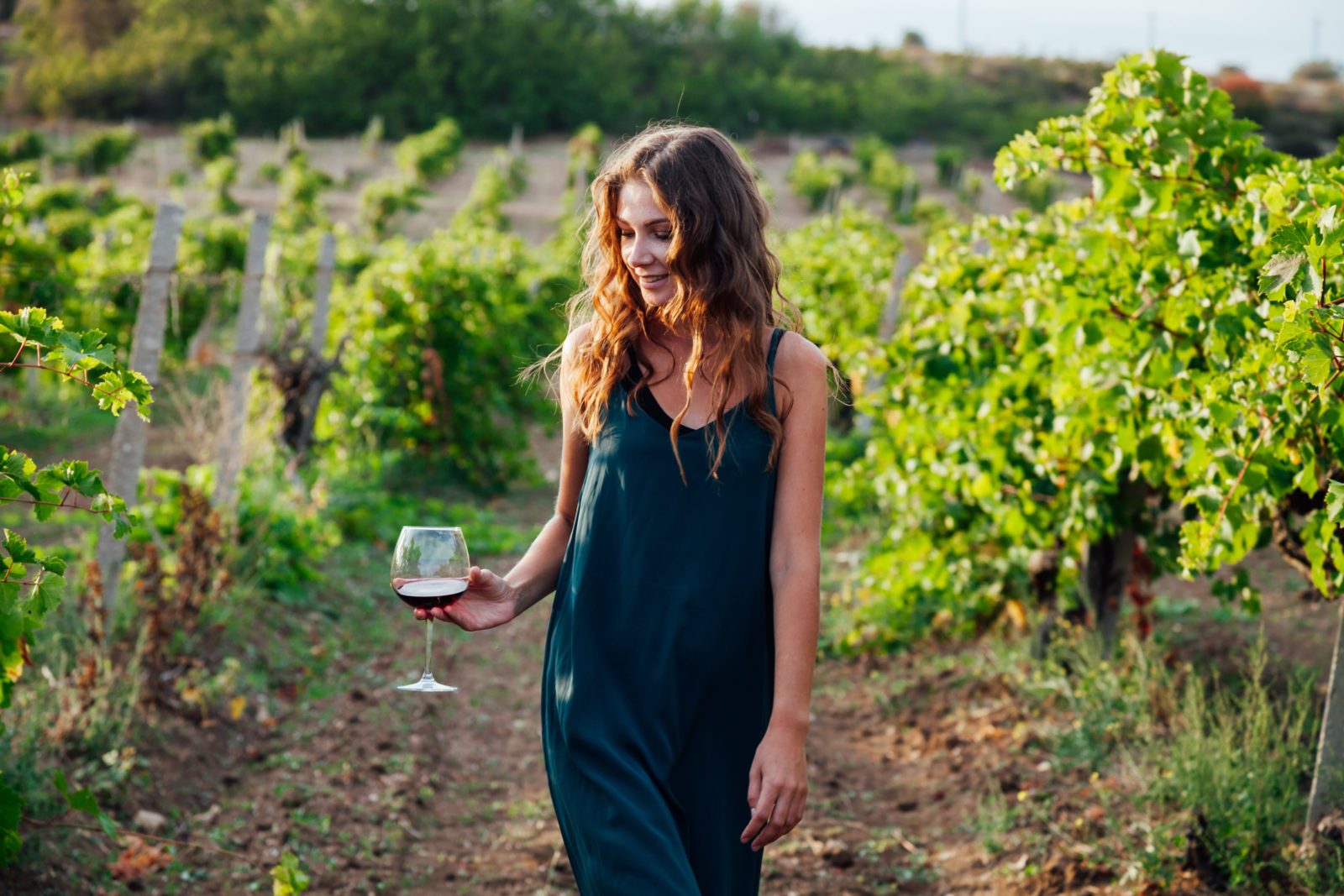 Enjoying a glass of wine strolling in the vineyard