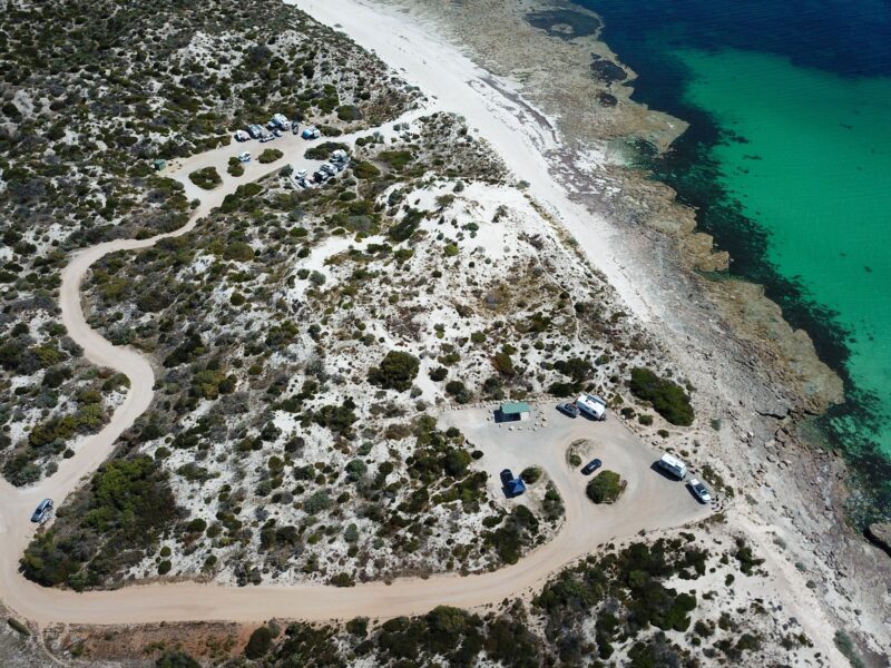 Drone view of sand track access, white sand beach, reef, aqua water