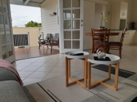 Outside patio area with seating, french doors, nest of coffee tables, dining table and 4 chairs