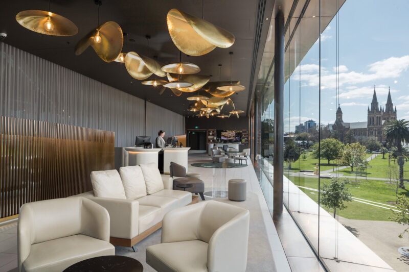 Oval Hotel reception lounge area featuring check in desk, bar and lounges all overlooking parklands