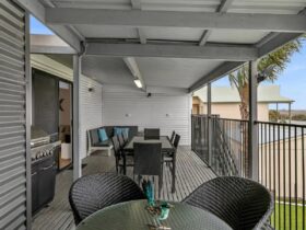 Balcony with dining tables, lounge area and BBQ. Balcony access from lounge room and river view room