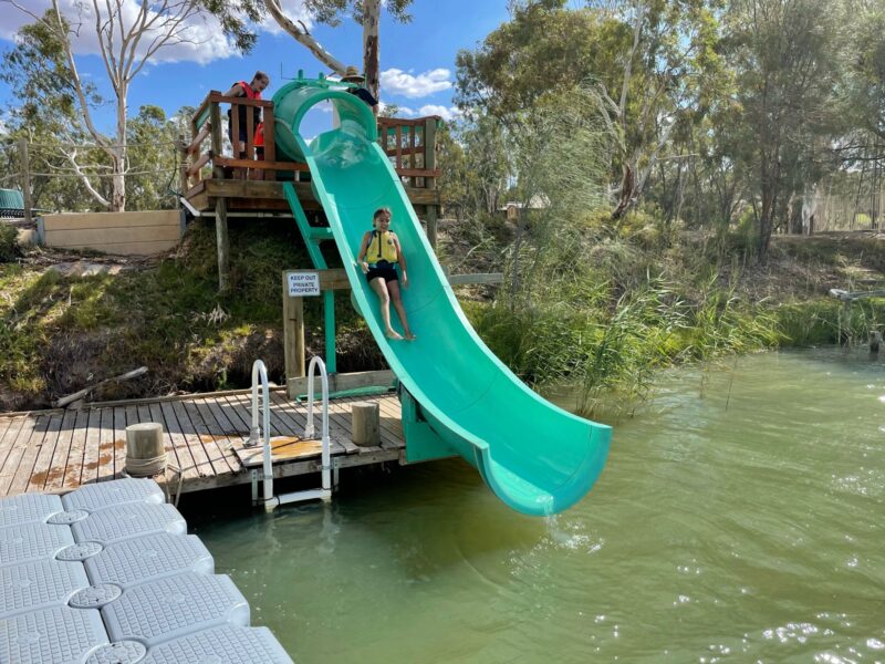 Child coming down waterslide into Murray River at Roonka River Adventure Park