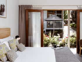 A king-sized bed with Scandinavian-style furnishings, overlooking a garden