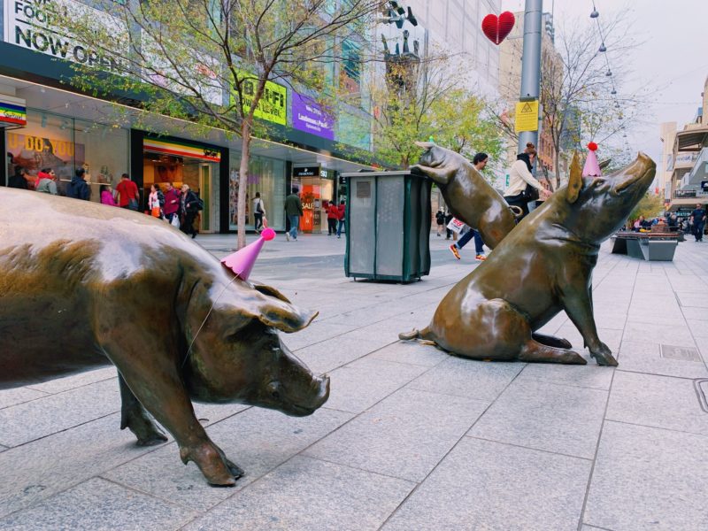 Two bronze pigs wearing party hats