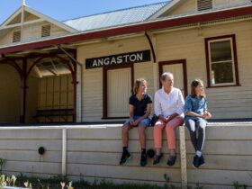 Adult and two children sitting on the Angaston Railway Station platform