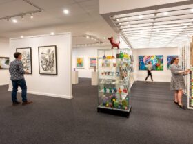 A photo of Art Images Gallery interior, showing art on the walls and a glass cabinet of sculpture.