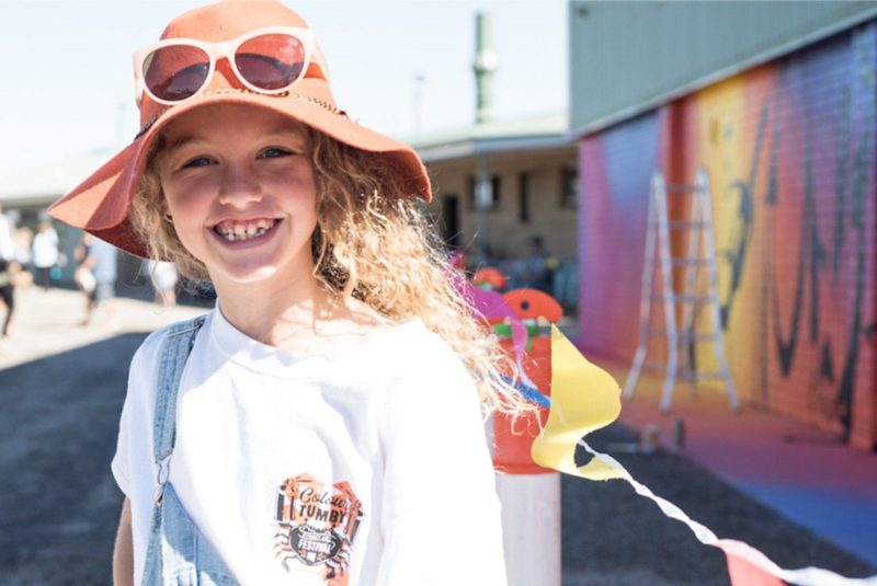 Curly haired girl in front of George Rose Mural 2018