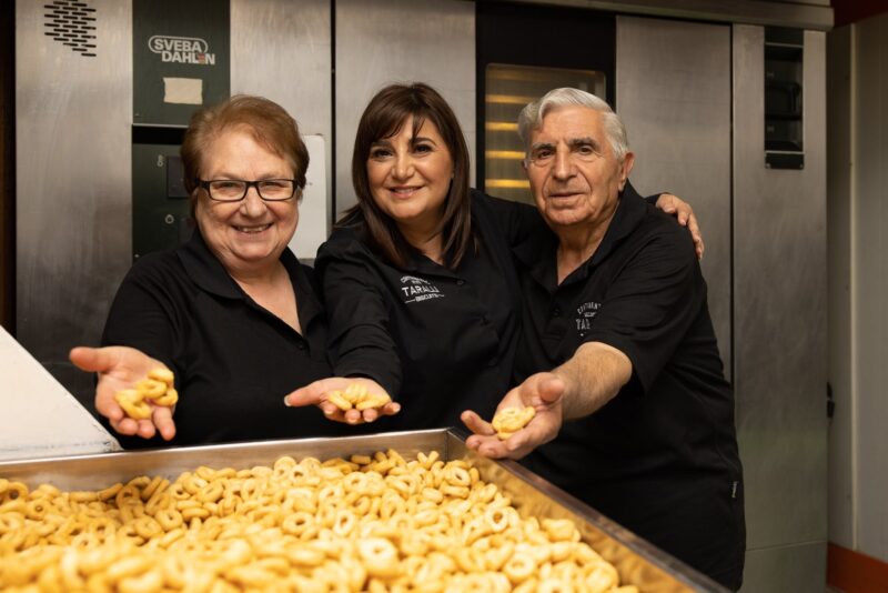The Bruno family standing behind a large tray of their locally-made savoury biscuits