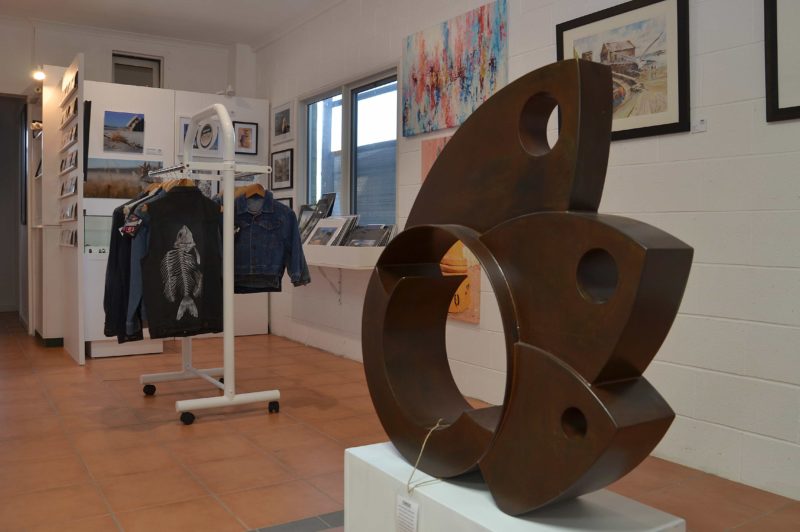 Rear of the gallery showing metal sculpture, denim jackets and photographic prints