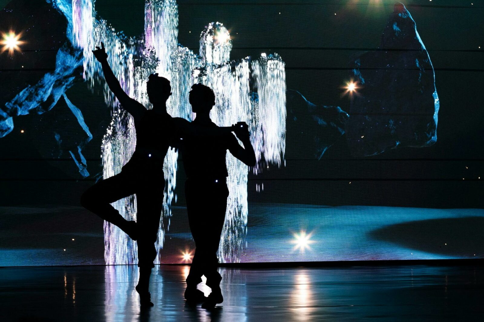 Two dancers with a backdrop of interactive LED screens