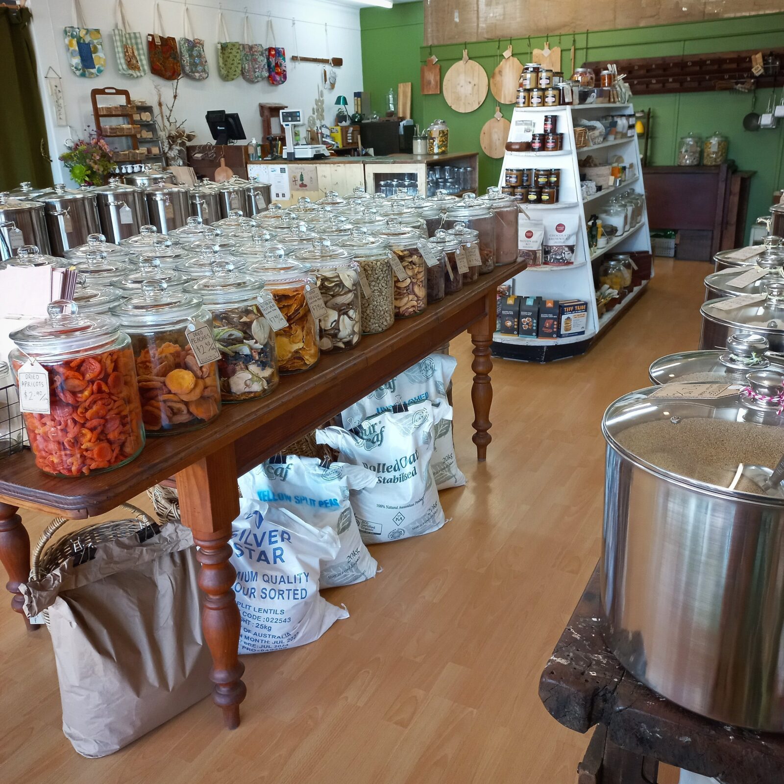 Inside view of Nourish Home & Pantry. Dried fruit filled jars, bags of organic flour flour.