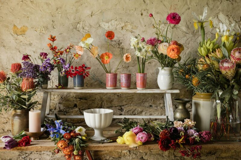 Spring flowers, native flowers in brightly coloured vases, ready for arranging in an old building