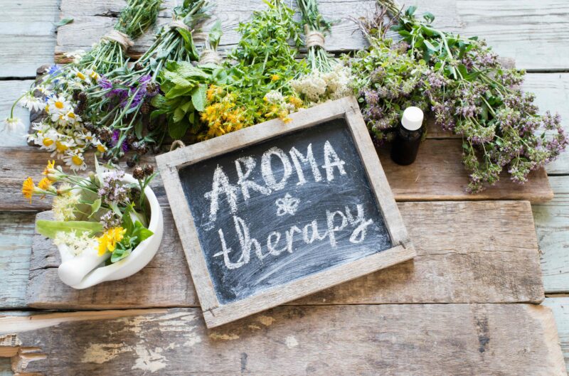Herbs surround a sign reading "aromatherapy"