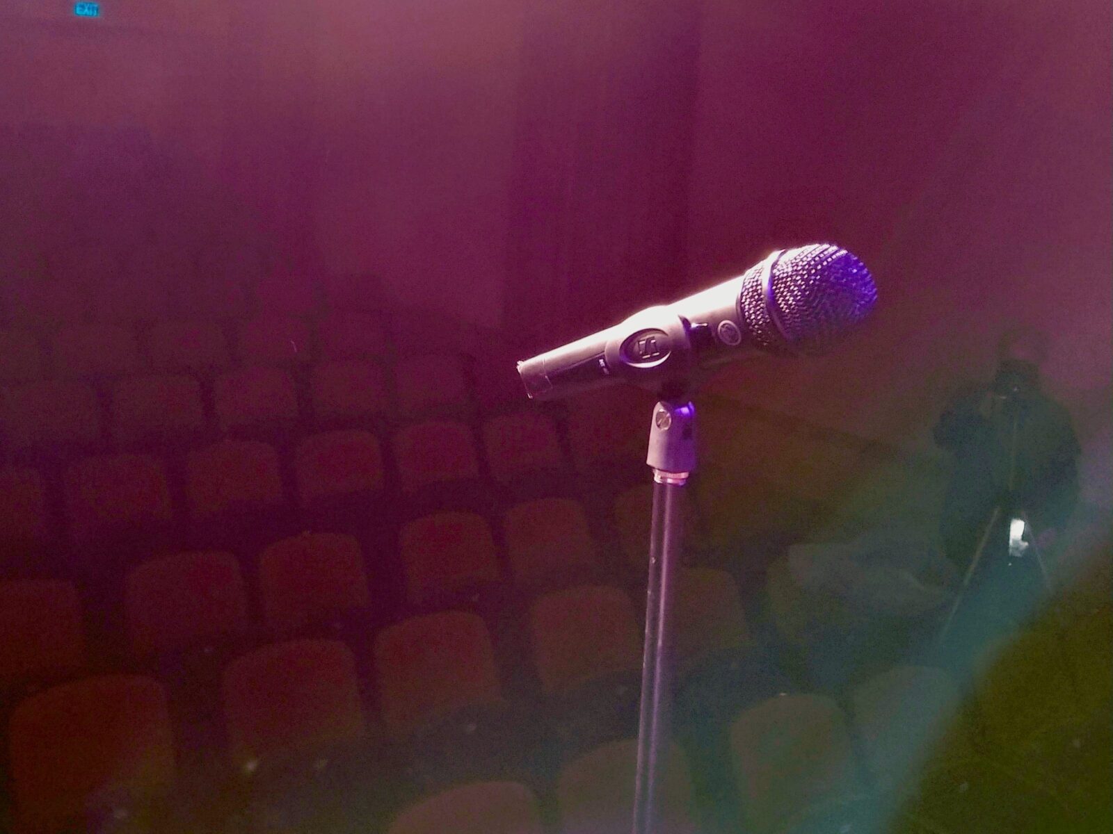 a stage-lit microphone awaits its performer and audience