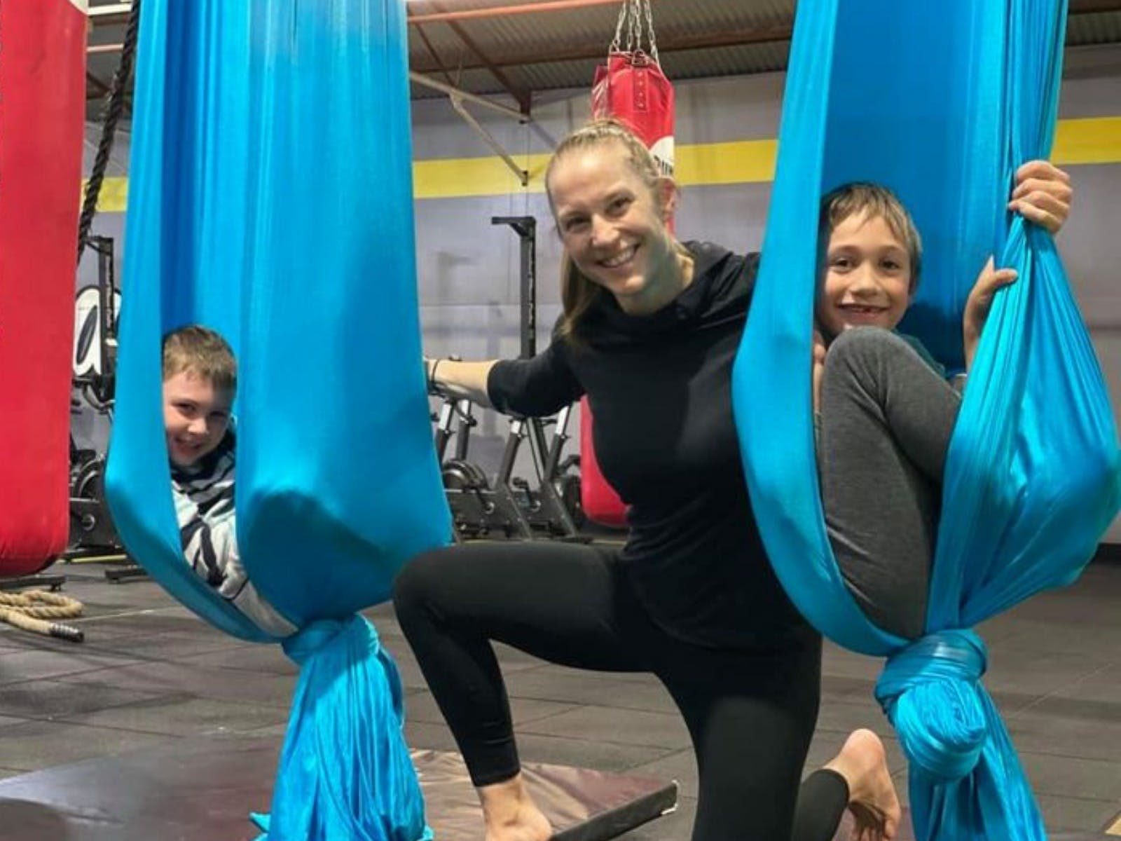 Two participants in blue silks aerial with instructor in-between