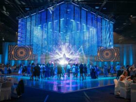 Image of an event hall with people on the dancefloor, underneath a chandelier with blue lighting