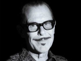 Portrait photograph in black and white, dramatically lit, of musician Kirk Pengilly