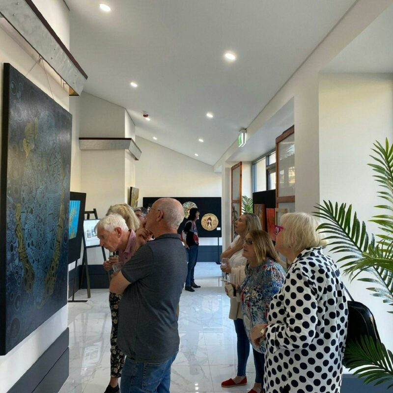 Onlookers viewing artworks at Links Lady Bay