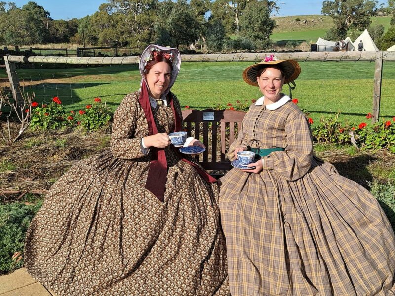 2 Victorian dressed ladies enjoying a cup of tea in the groounds of Glenbarr