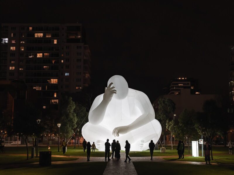 Large inflatable glowing man figure thinking.