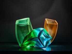 A glass art work featuring hues of green, blue and yellow against a black background
