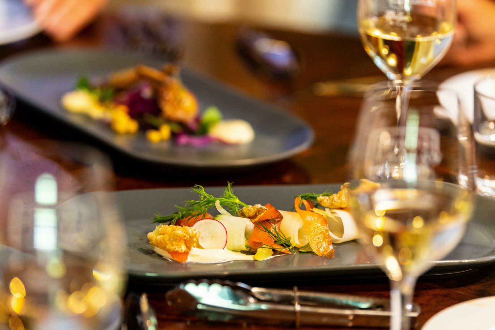 Two gourmet dishes at Reillys Restaurant with glasses of white wines