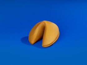 A golden fortune cookie on a blue cobalt background.