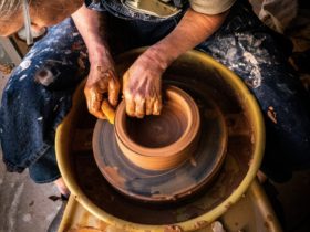 Woman throws pottery on a wheel
