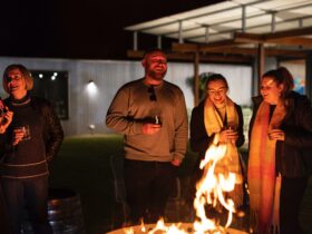 Friends gather around a fire put