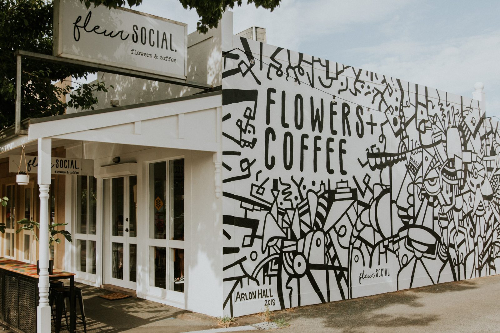 Fleur Social exterior shot including Flowers + Coffee and mural