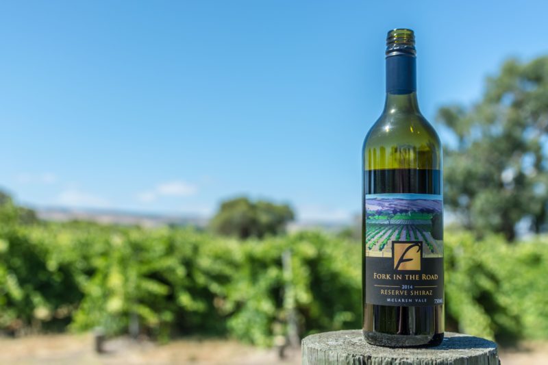 Our award winning shiraz in the focus of a photo of the rolling hills and vineyards.