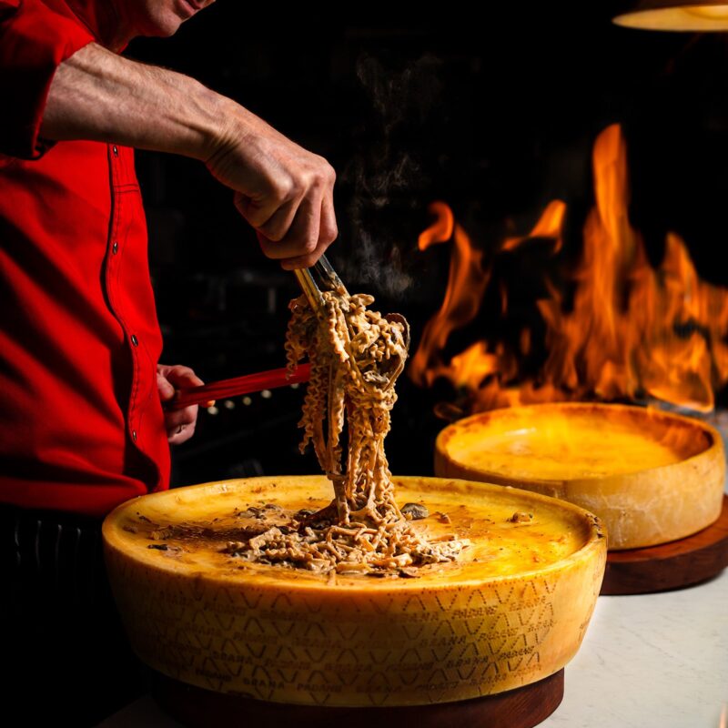 Flaming cheese wheel pasta