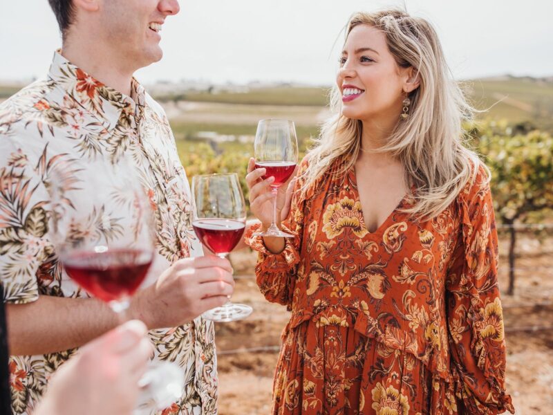 Couple enjoy glass of Grenache in front of vines