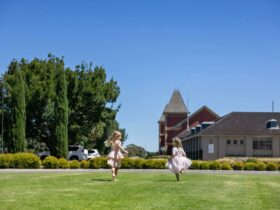 Two young girls running across the front lawn at Provenance Barossa.